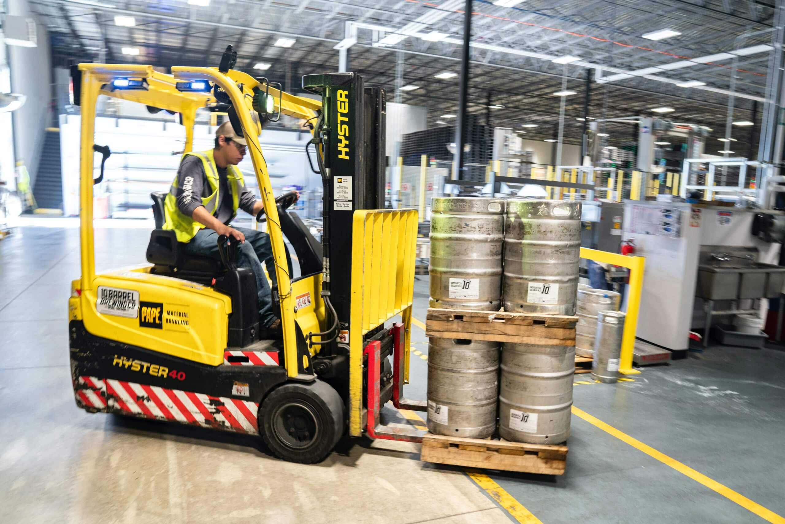 Warehouse worker using a forklift lifting pallets